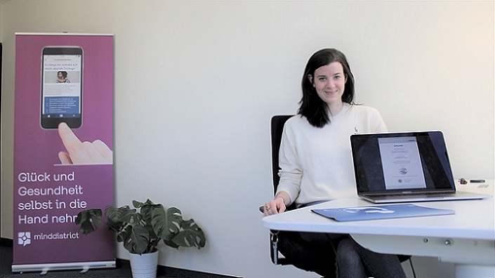 Theresa Meier am Arbeitsplatz mit Zertifikat