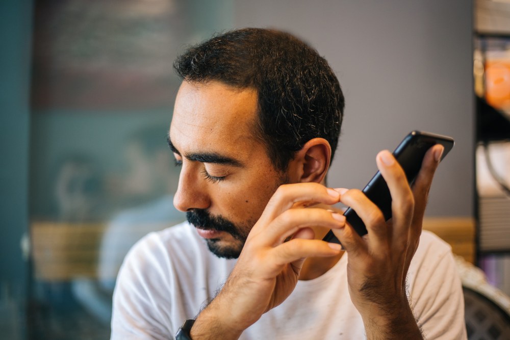 Photo of a blind man using his mobile phone