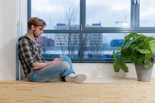 Mann am Fenster nimmt an Videosprechstunde teil