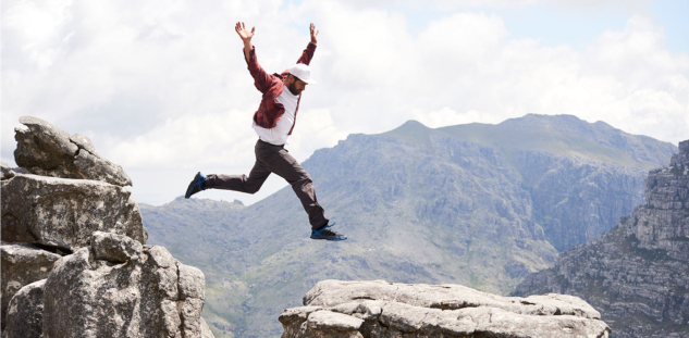 Man jumping for joy in mountain range